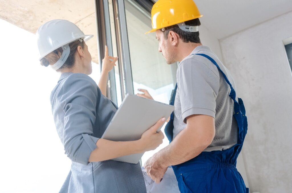 Architekt und Bauarbeiter bei der Überprüfung der Fenster auf der Baustelle